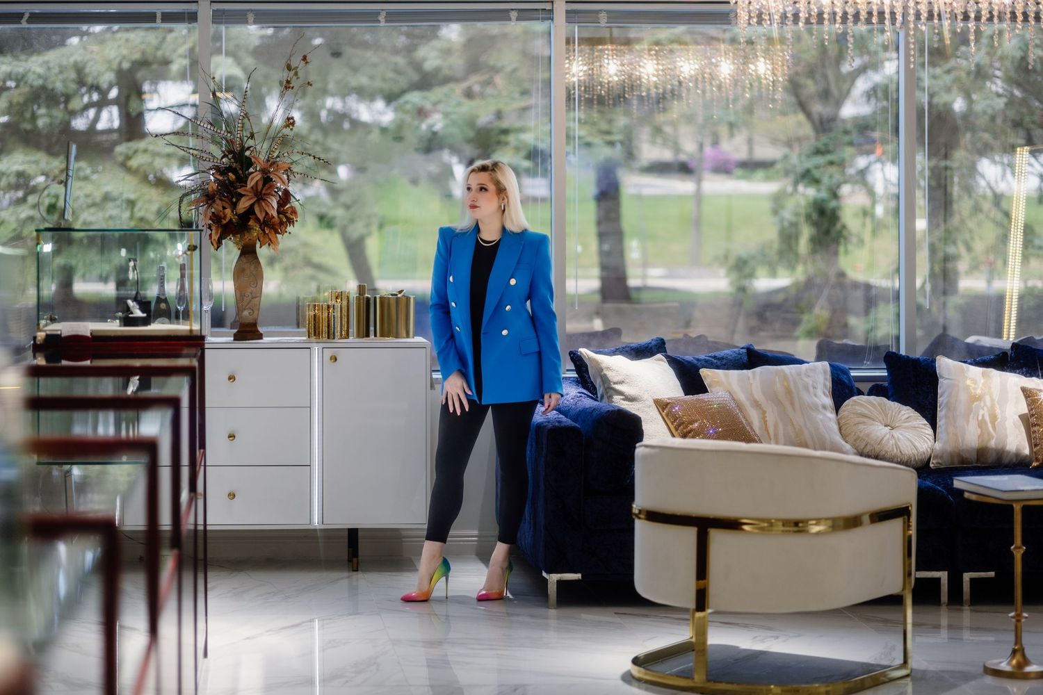 Elegant interior featuring a bright blue blazer and contemporary crystal chandelier.