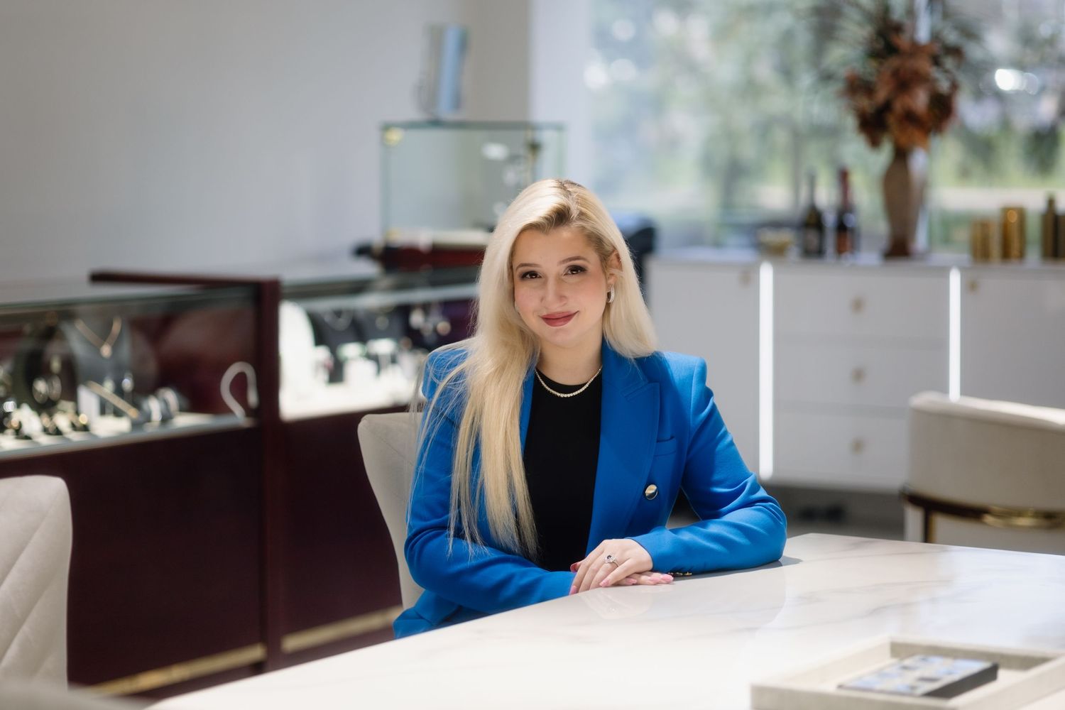 Professional business portrait in modern office setting with elegant decor and lighting.