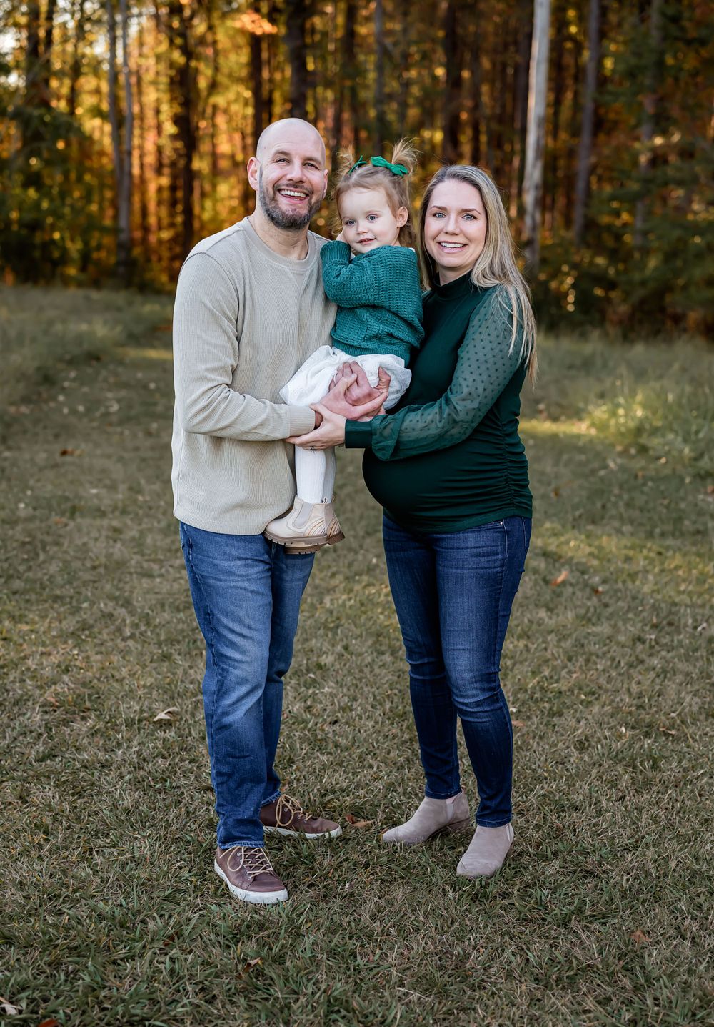 Family portrait in autumn forest with warm golden light.