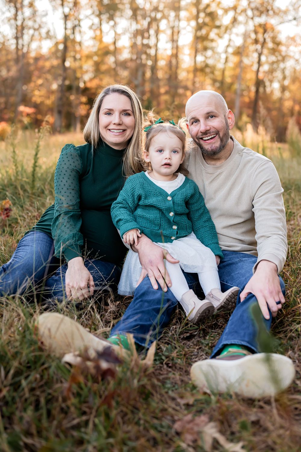 Relaxed family portrait session in fall forest setting.