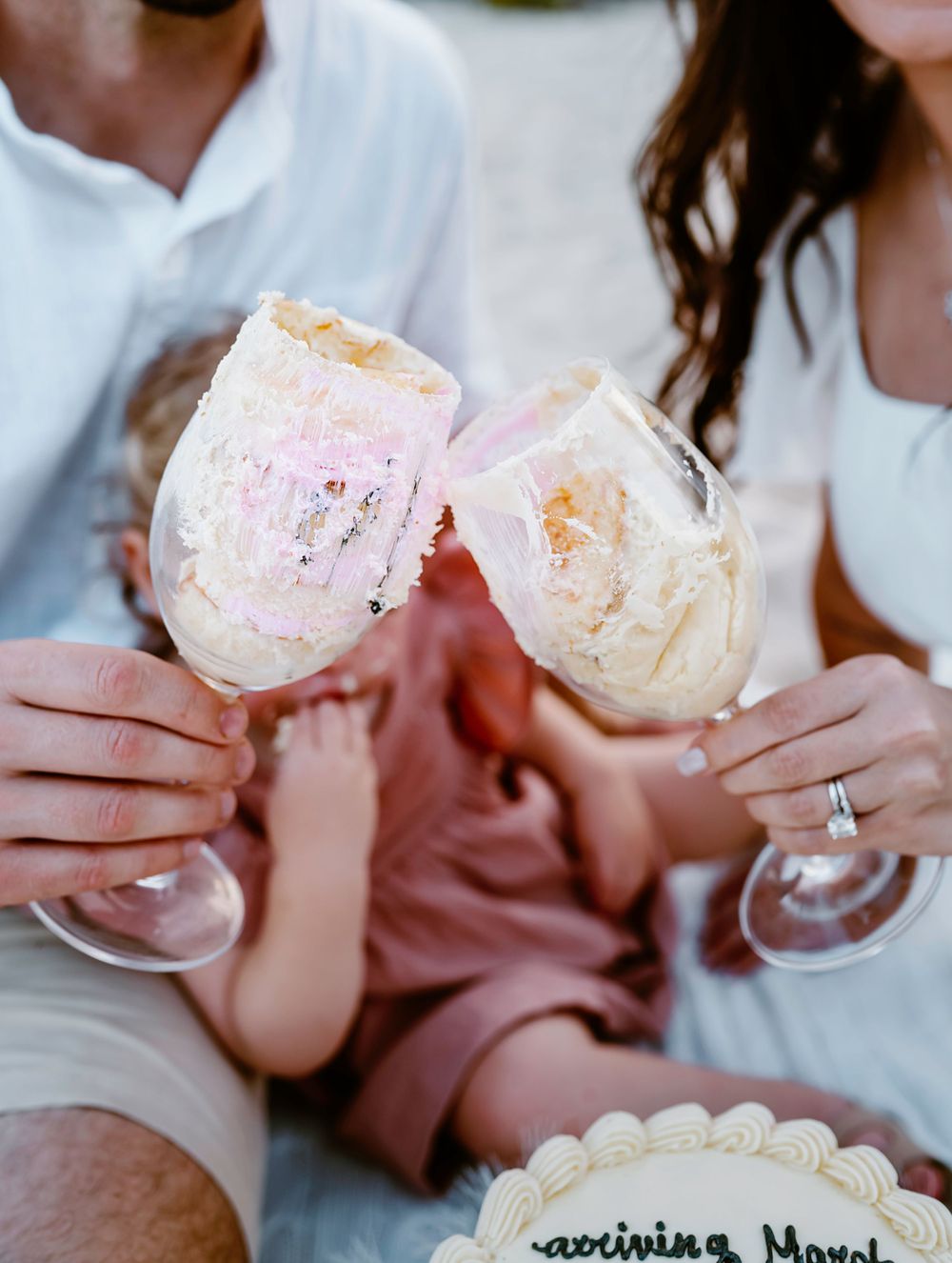 Couple toasting with milkshakes while relaxing on blanket outdoors.