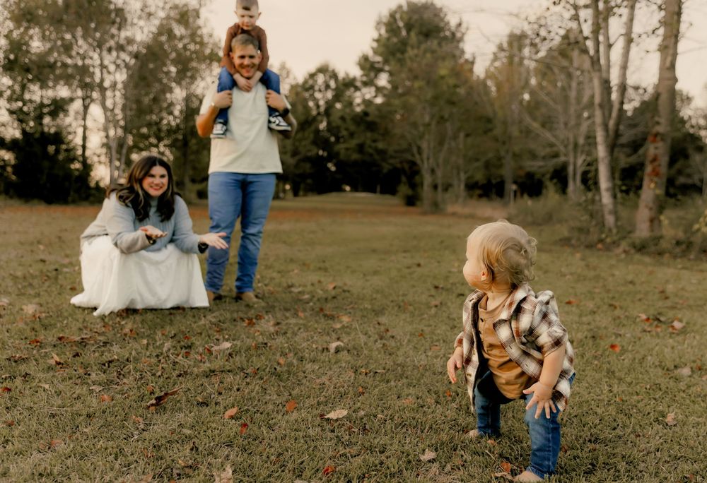 Natural outdoor family photography session in a rustic field setting.