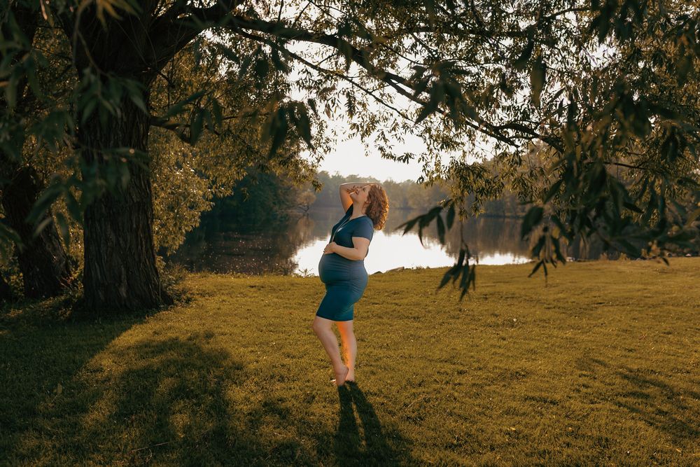 Confident expectant mother posing outdoors during a golden hour maternity session in Wisconsin.