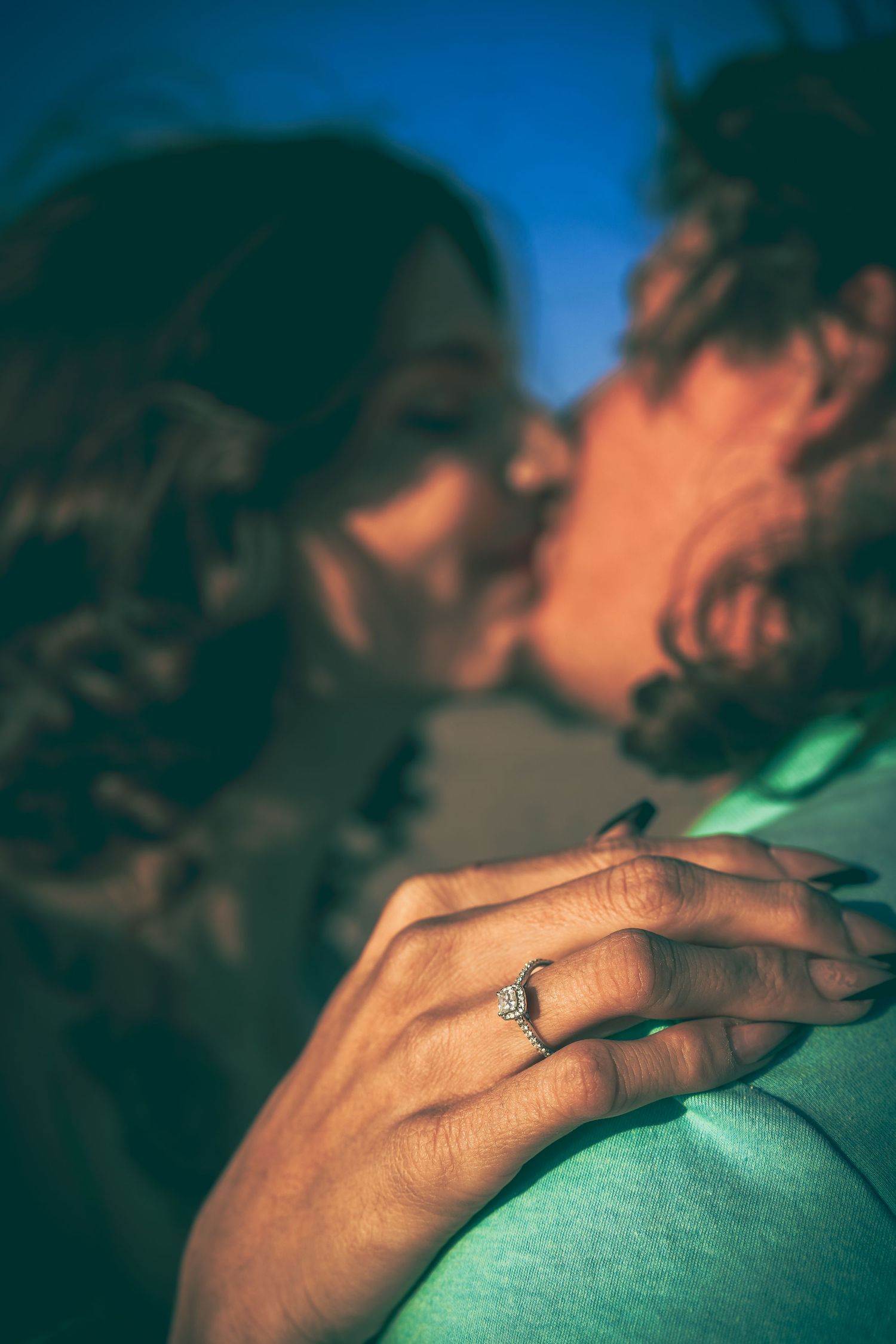 A close-up view of a sentimental moment showing a hand with an engagement ring on the finger.