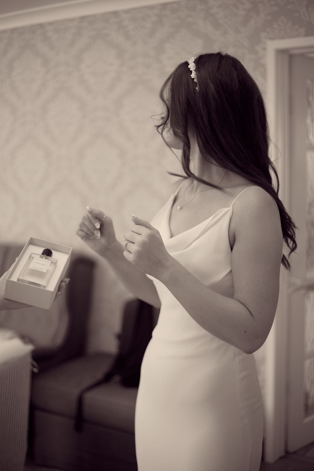 A series of black and white shots showing someone in a white dress tossing papers in an indoor space.