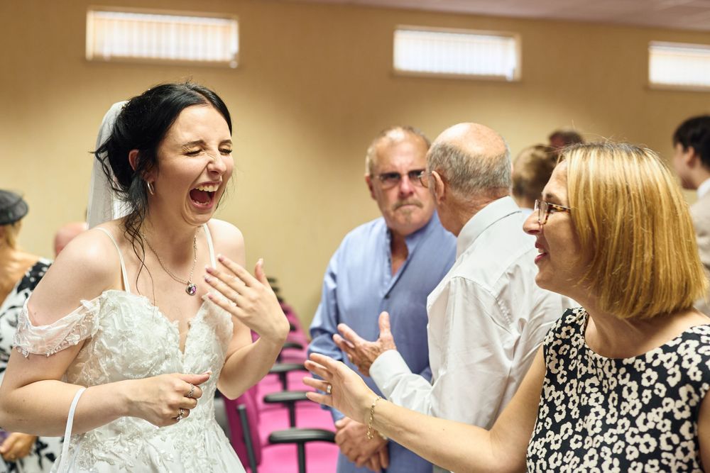 Wedding reception guests laughing and celebrating together in joyful candid moments.