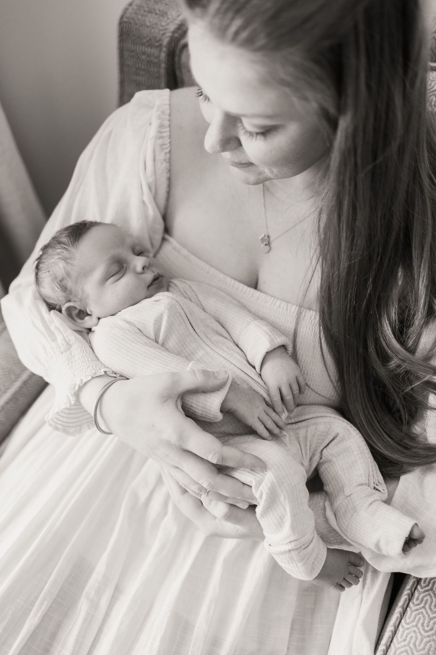 mom and dad holding baby son's hands