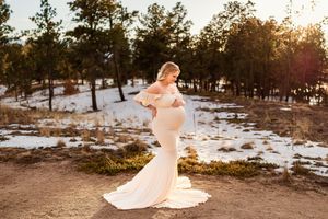 A romantic couple dances in a snowy forest landscape during golden hour as the bride's white dress twirls gracefully.