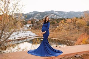 A flowing royal blue dress twirls dramatically against a desert mountain landscape during golden hour.