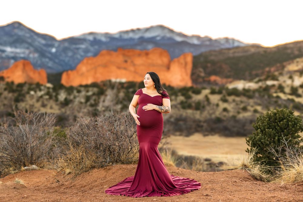 Dramatic maternity portrait in burgundy dress at Garden of the Gods.