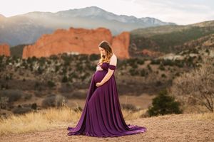 A flowing purple gown creates a dramatic silhouette against the backdrop of red rock formations in Garden of the Gods.