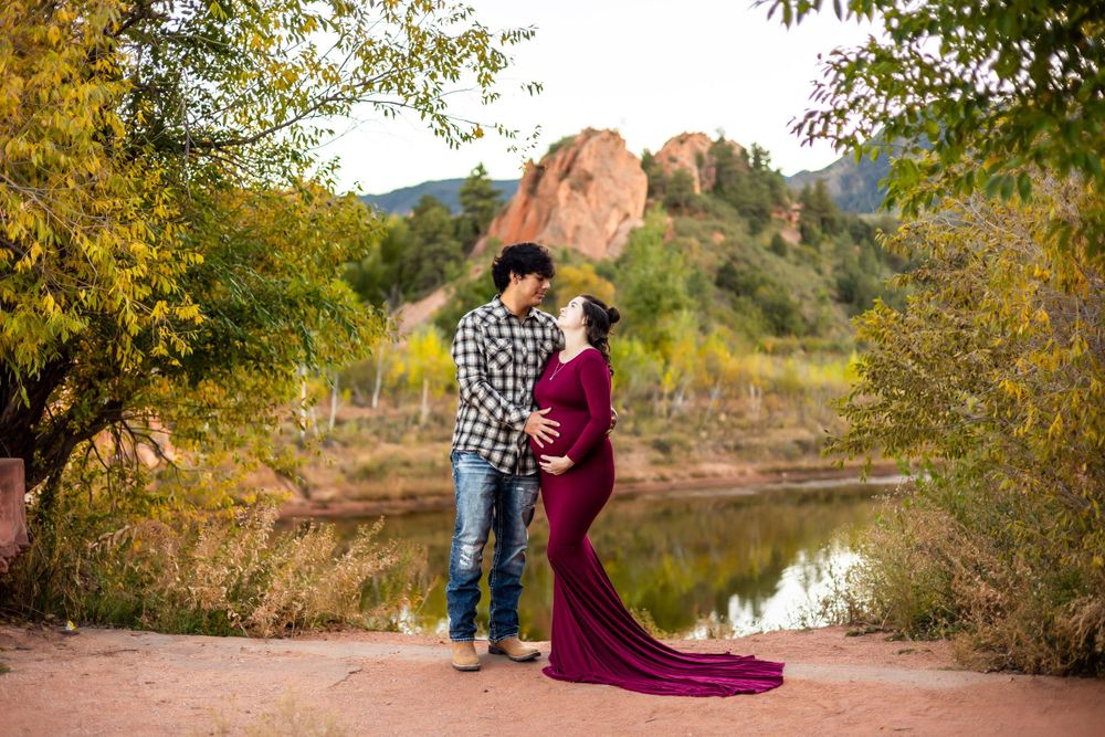 A maternity photo session at Garden of the Gods with red rocks in the background.