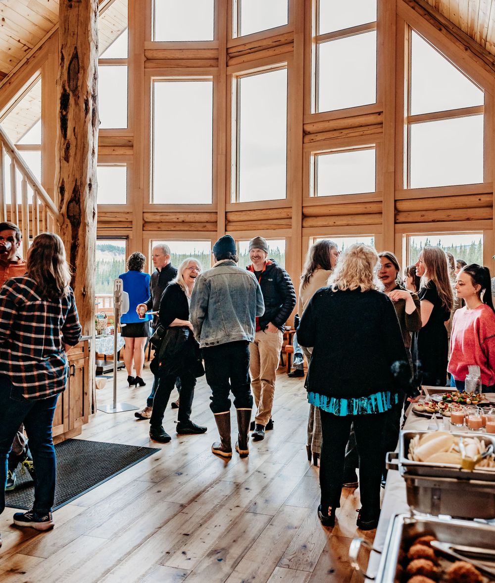 Business networking event in modern lodge venue with floor-to-ceiling windows.