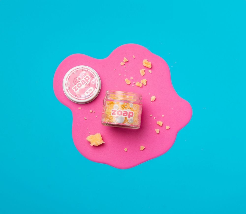 Metro Detroit Commercial Photographer captures product jar and lid on vibrant pink organic shape against turquoise blue background.