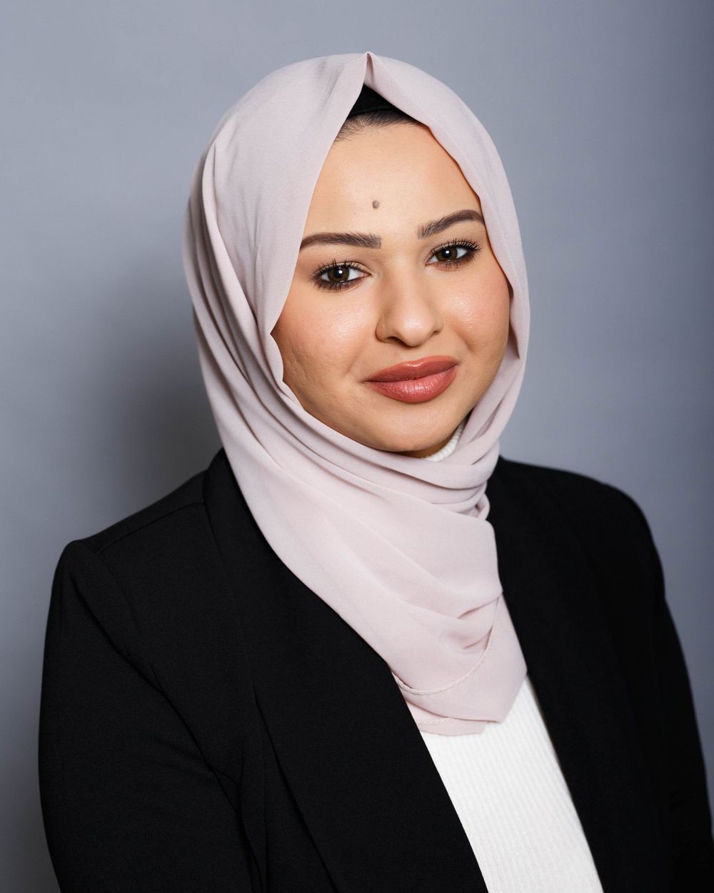 Professional portrait series showing a person in a light hijab and black blazer against a gray background with various expressions.