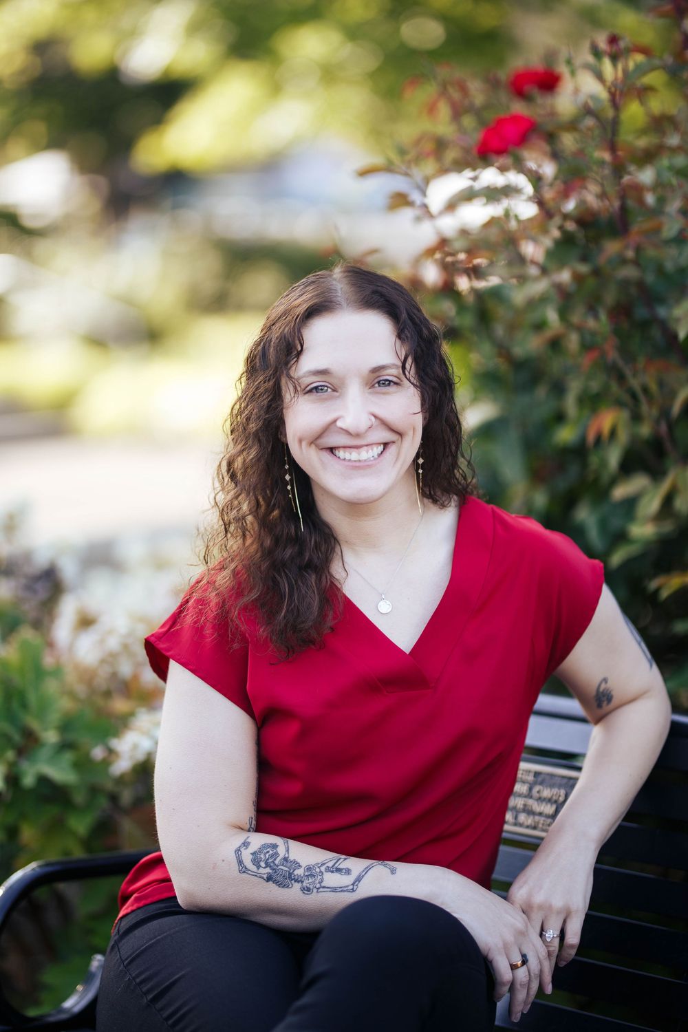 Edmonds headshot photographer: A professional mental health therapist sits on a bench at an outdoor headshot session in downtown Edmonds WA