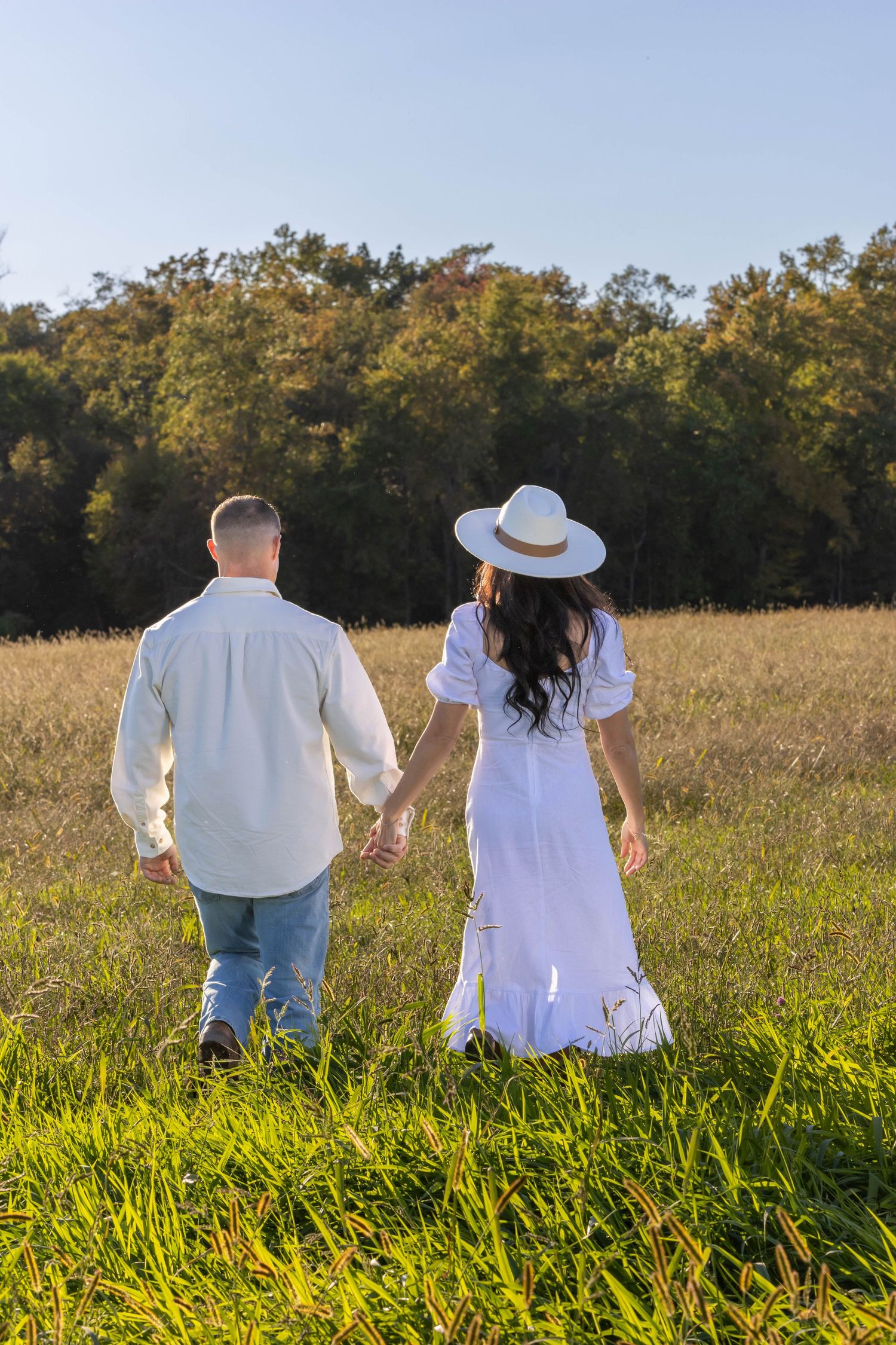 engaged couple walking in a field right before sunset. Salem and Gloucester County Photographer