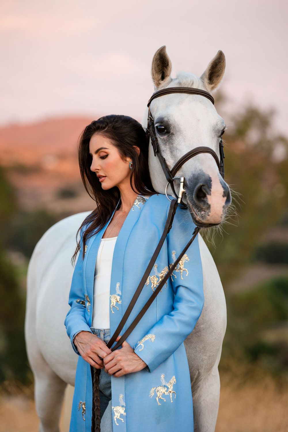 Editorial fashion shoot featuring model and horse in open field. San Diego