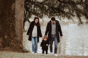 Family walking together along a waterfront path on an autumn day.