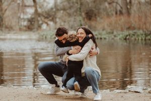 Family sharing a playful moment together by the water.