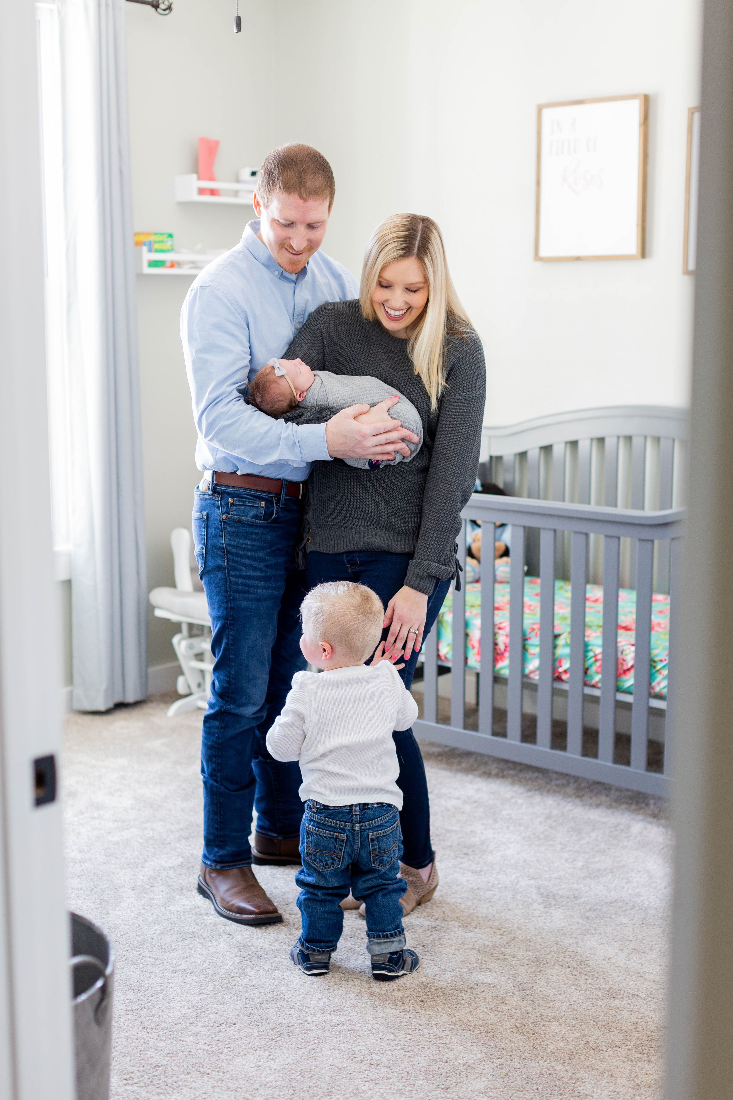 Sweet family holding their newborn baby in their nursery taken during a lifestyle session in Springfield, Missouri.
