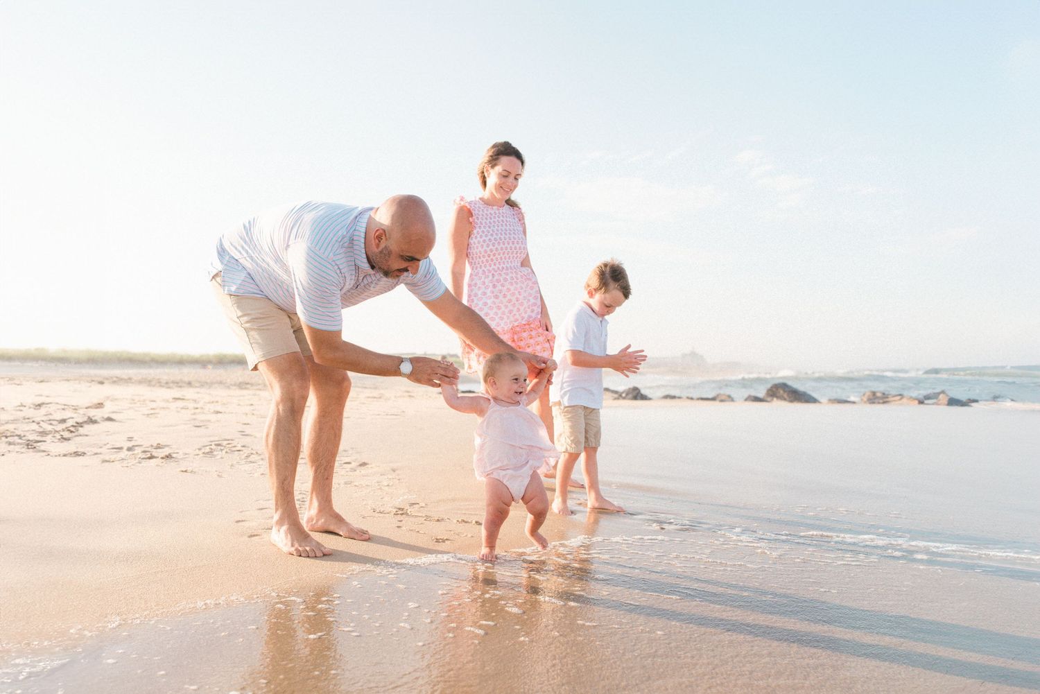 family at the beach jumping into the water in New Jersey.