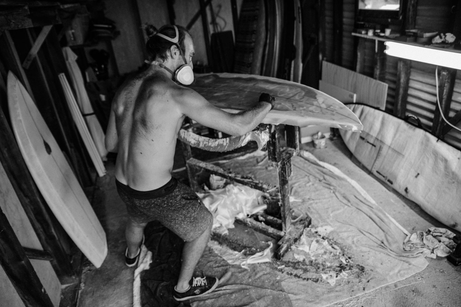 Workshop scene showing woodworking and surfboard shaping tools.