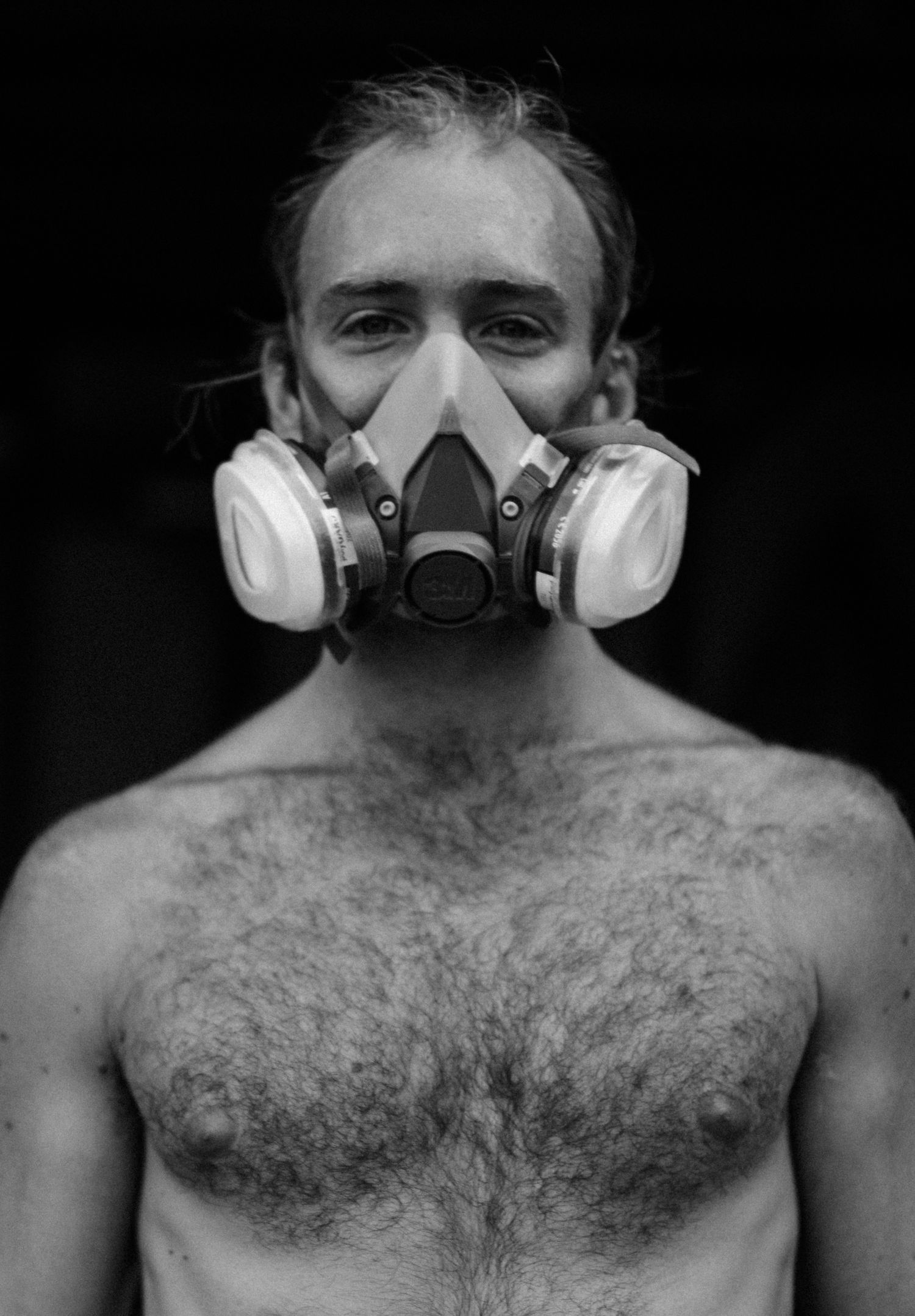 Series of black and white portraits showing someone wearing a protective respirator mask.