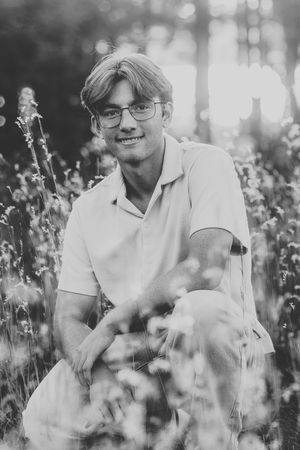 Black and white portrait among wildflowers with dreamy bokeh effect.