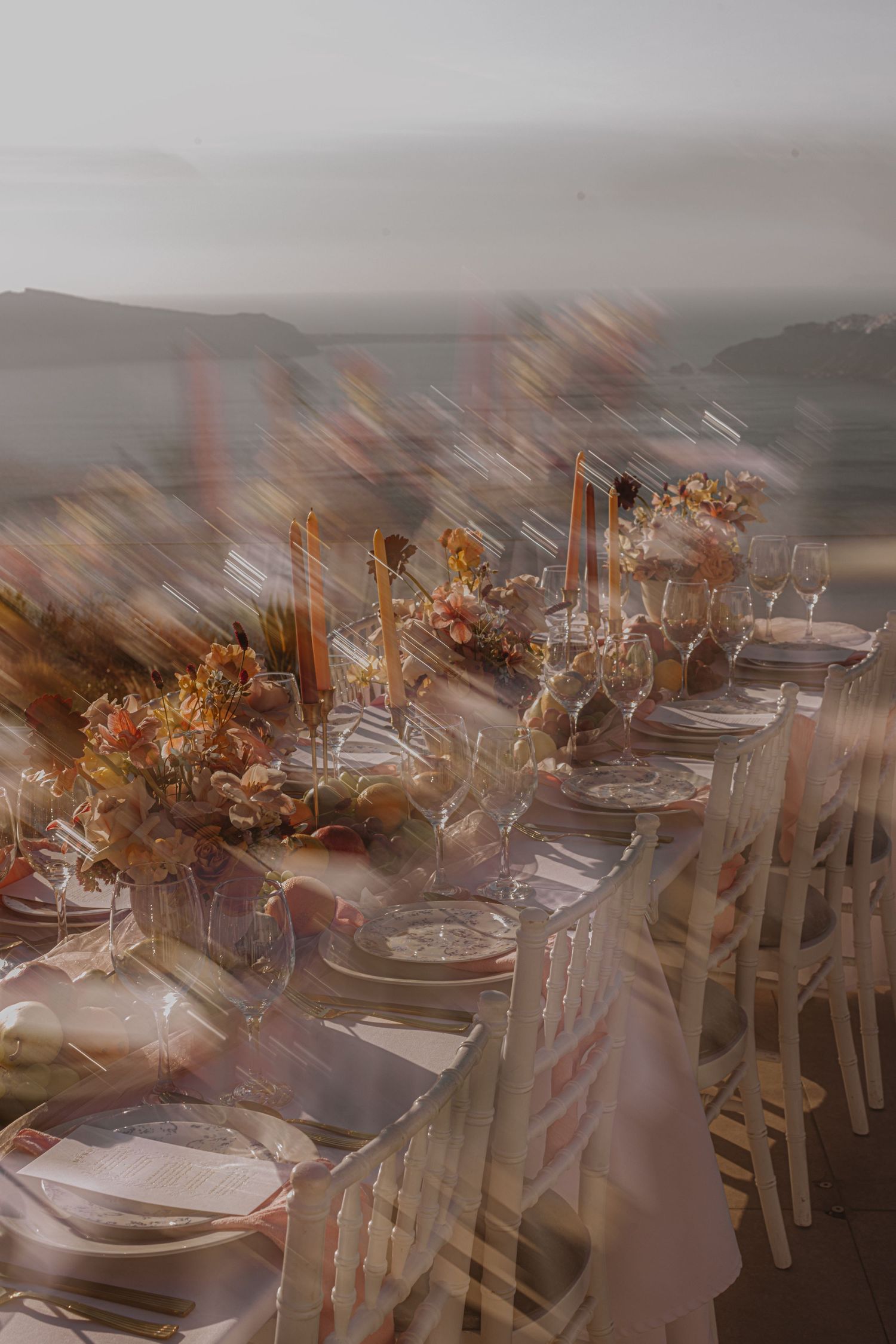Elegant wedding reception table setting with autumn floral arrangements and place settings in a banquet hall.