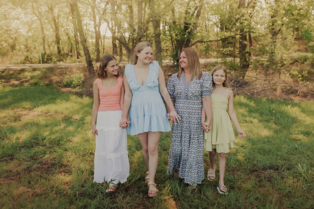Family smiling and laughing in a field during a family session in Wimbledon