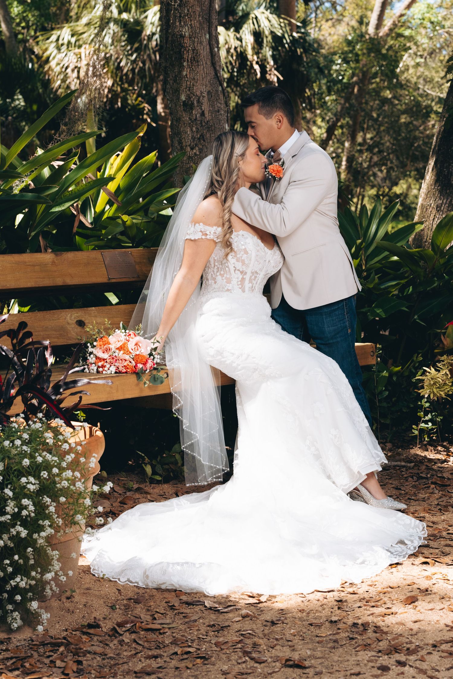 Romantic wedding portrait in a lush garden setting with flowing white dress.