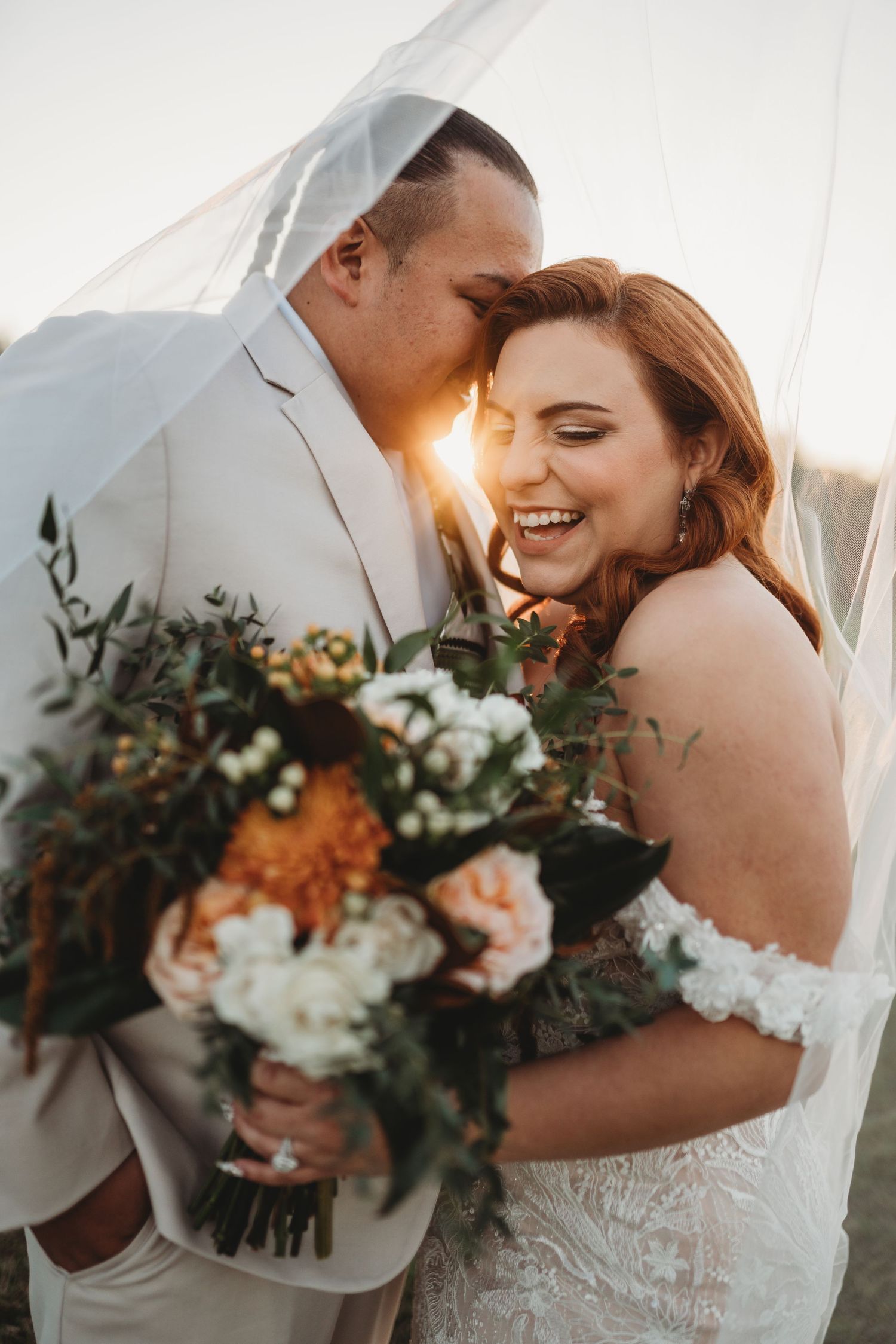 Sunset portrait of couple sharing joyful moment with autumn-colored bouquet.