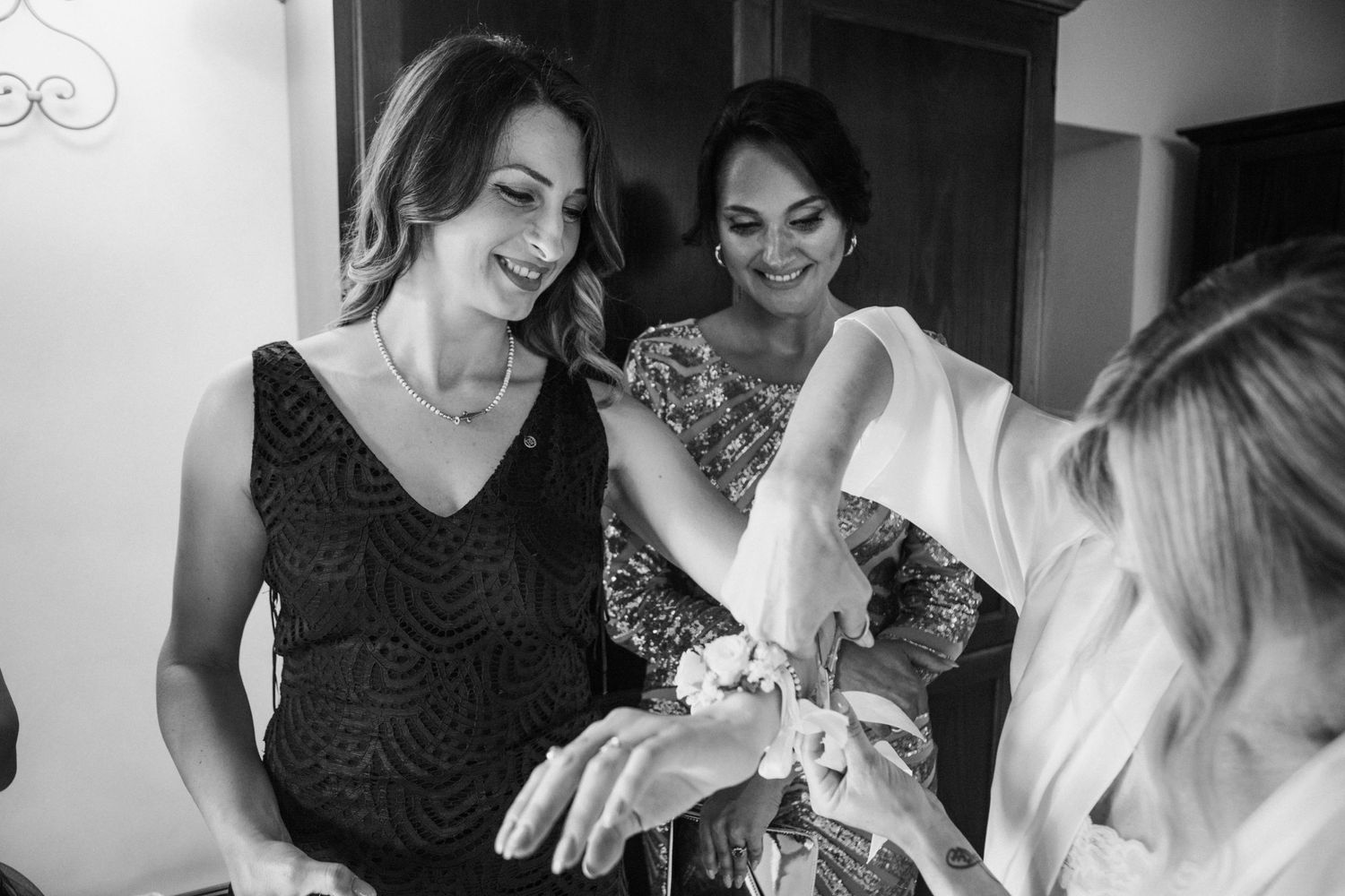 Black and white candid moment of wedding preparations.