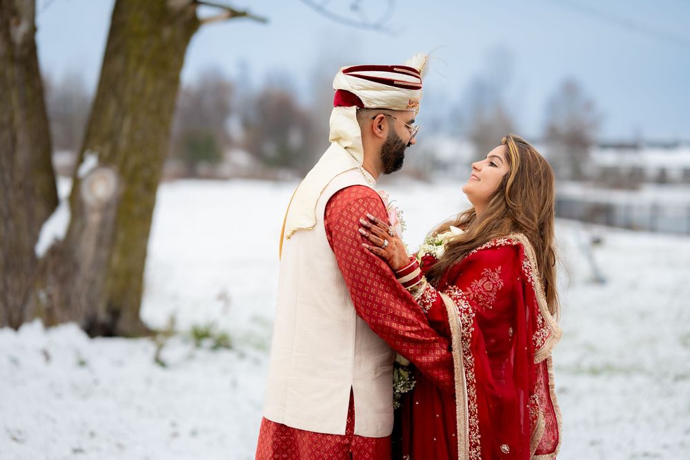 Winter engagement photos in snowy landscape with traditional Indian wedding attire.