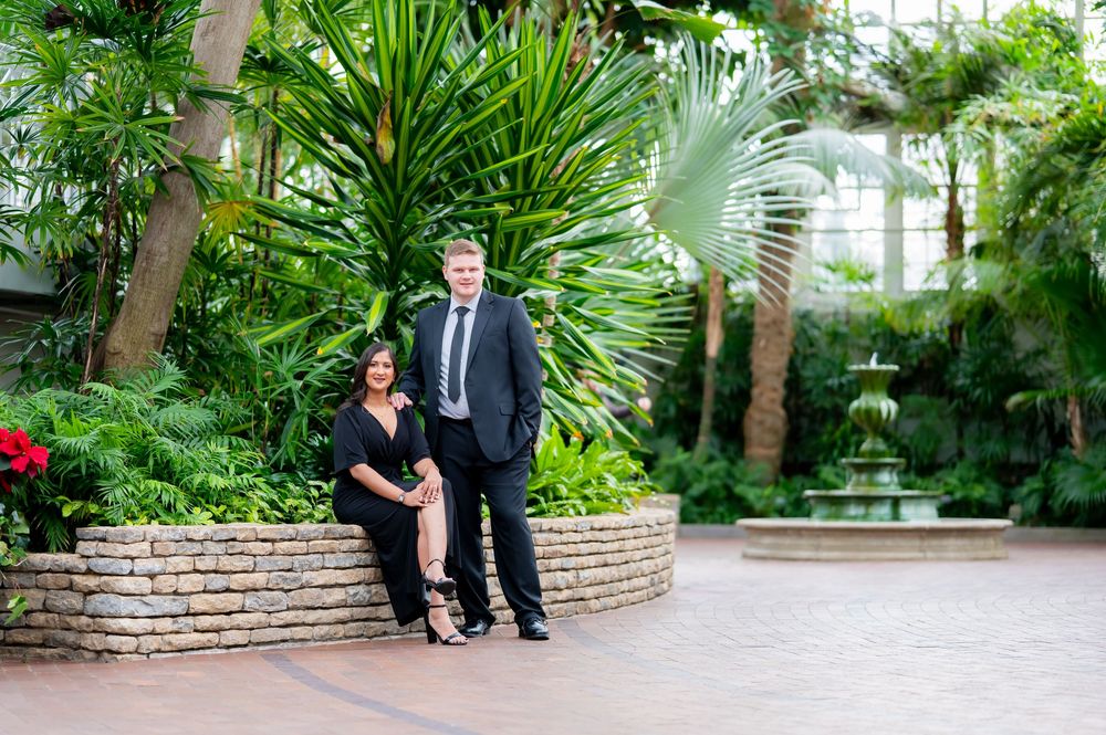 Indoor botanical garden engagement photography session with palm trees and natural light.