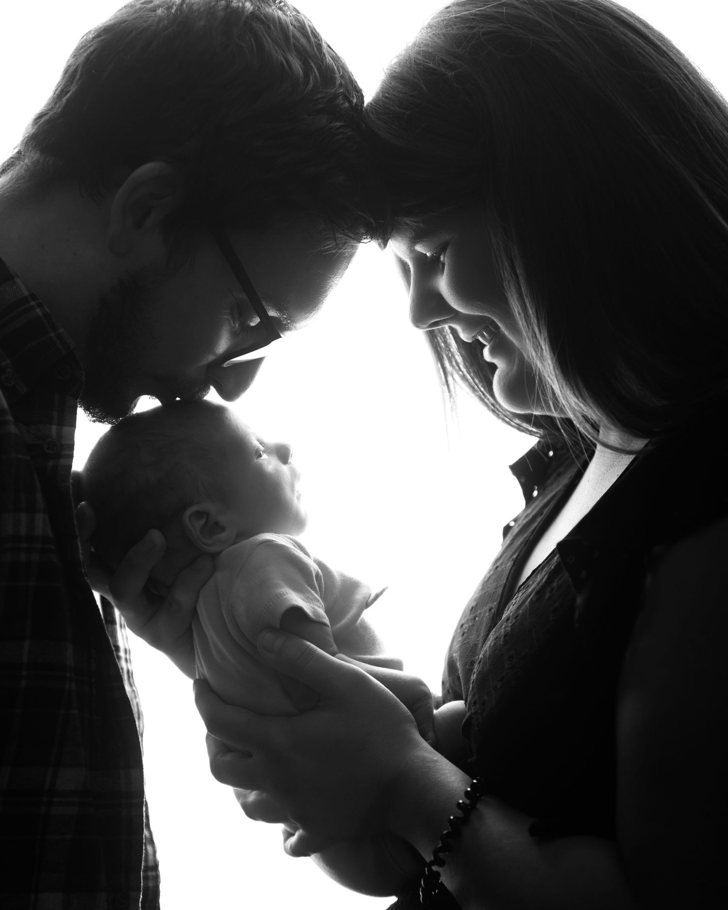 Intimate black and white silhouette portrait of a tender family moment.