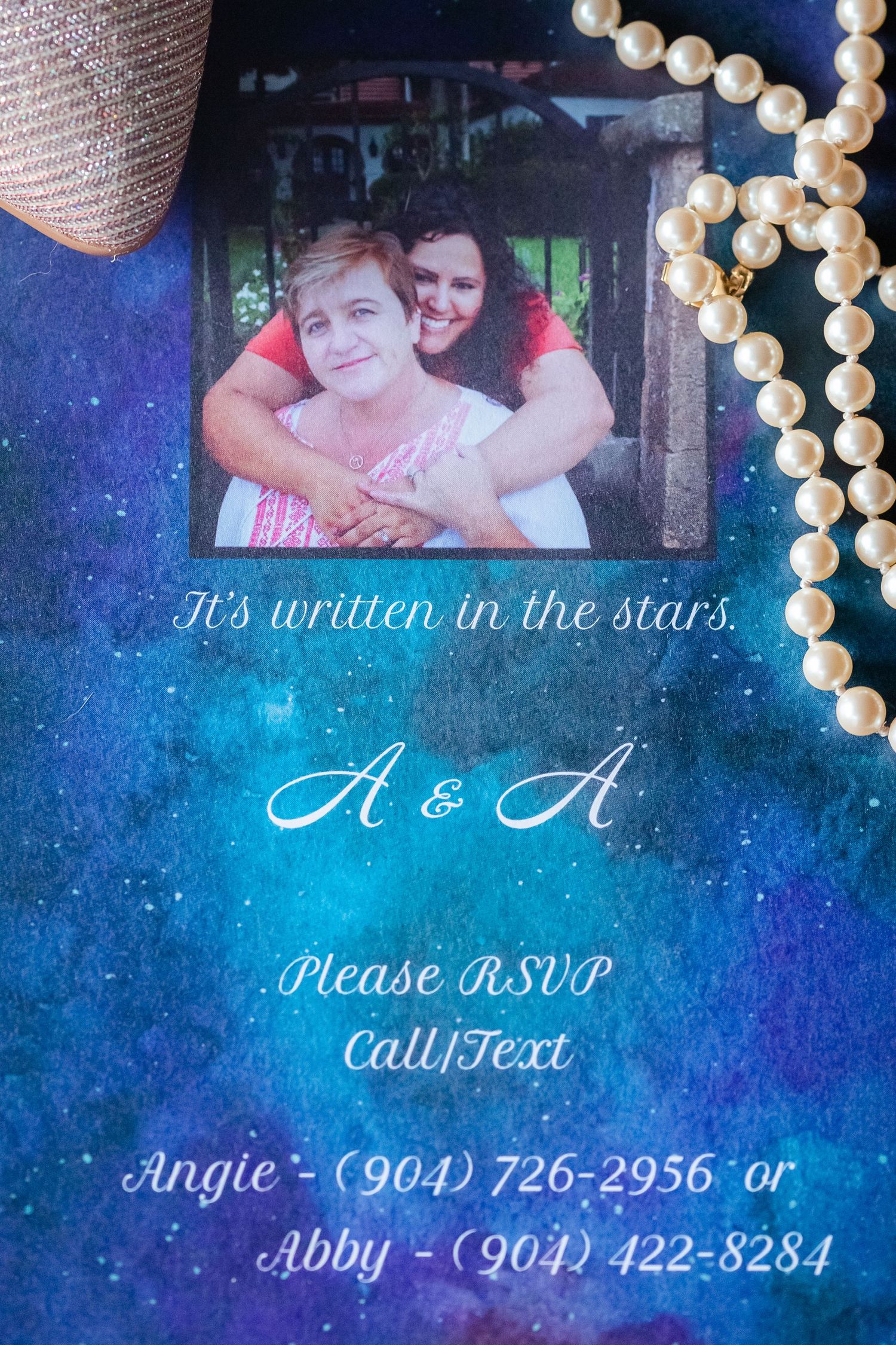 Wedding invitation with celestial theme featuring pearl decorations and starry blue background.