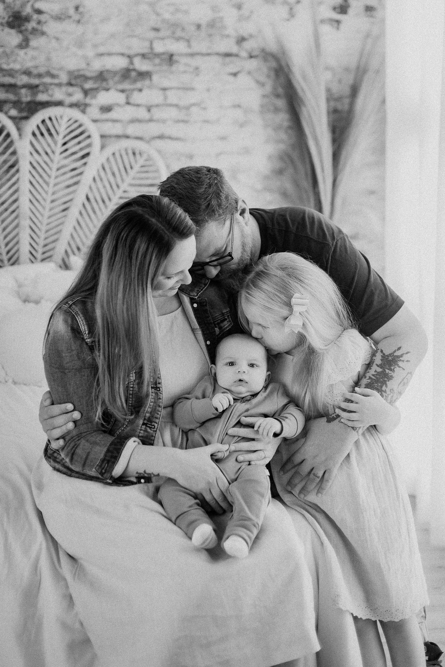 Black and white portrait of a loving family moment with a baby.