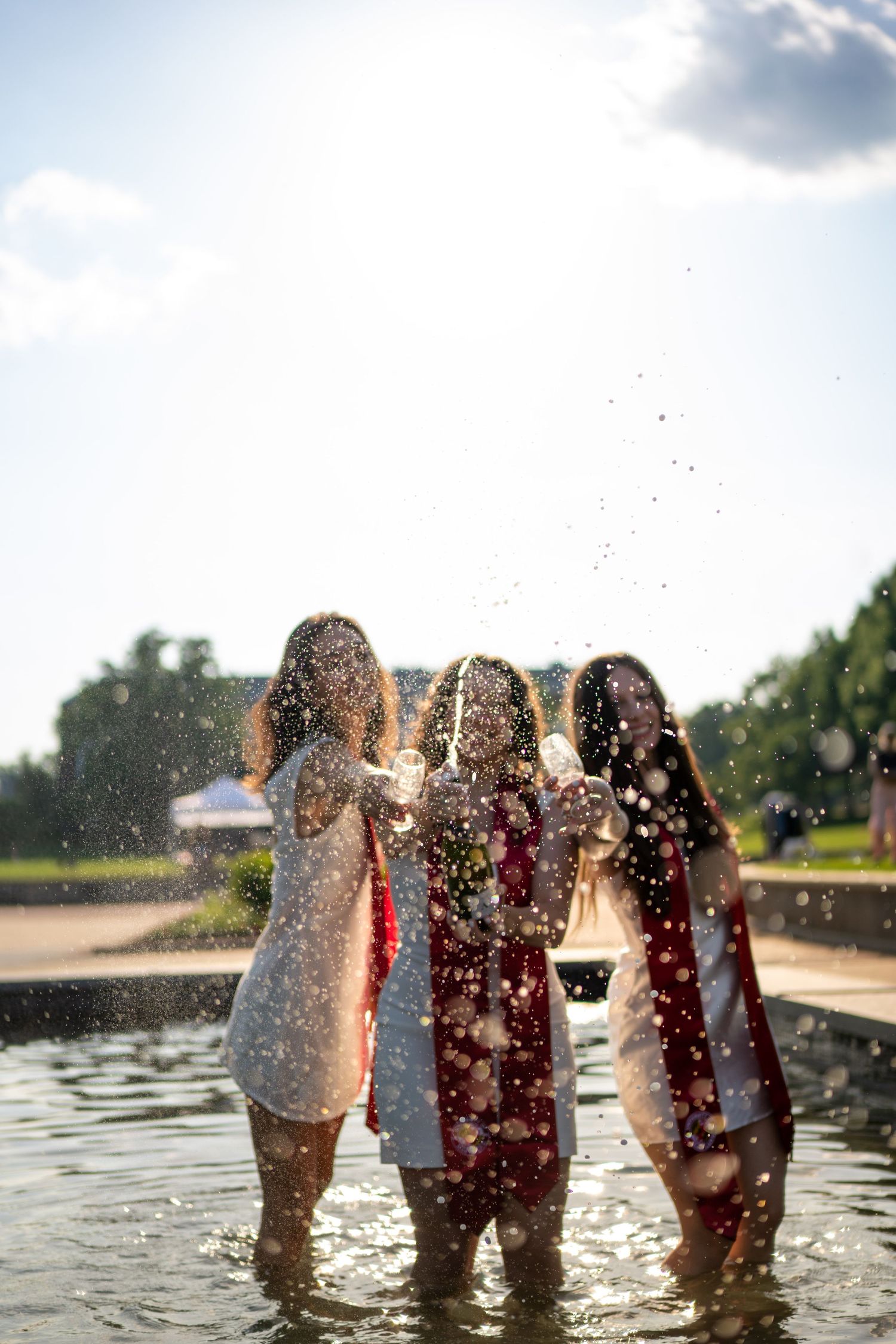 Feet splashing in water during sunset creating playful water droplets and reflections.