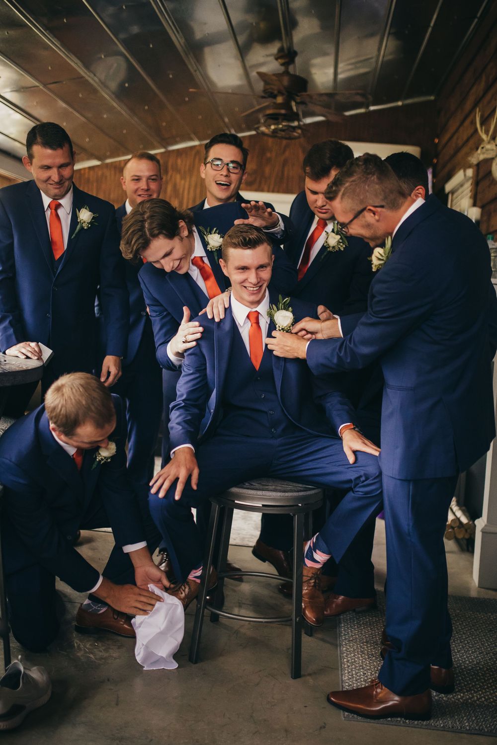 groomsmen jokingly help neaten up groom