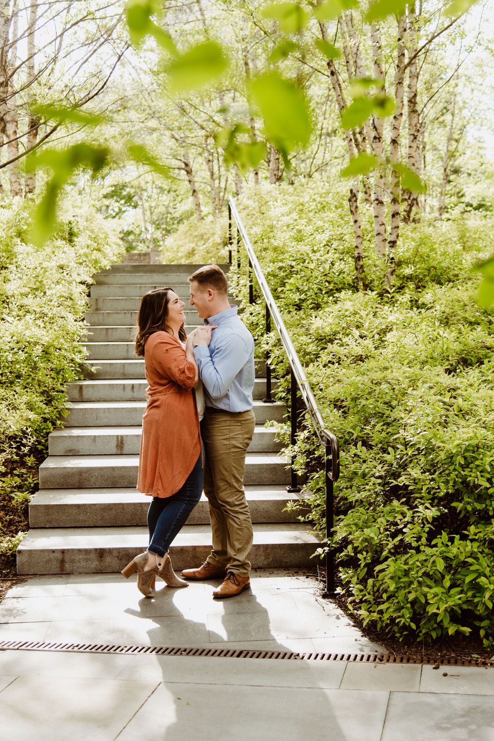 Romantic sequence showing a couple dancing together on outdoor steps with green foliage.