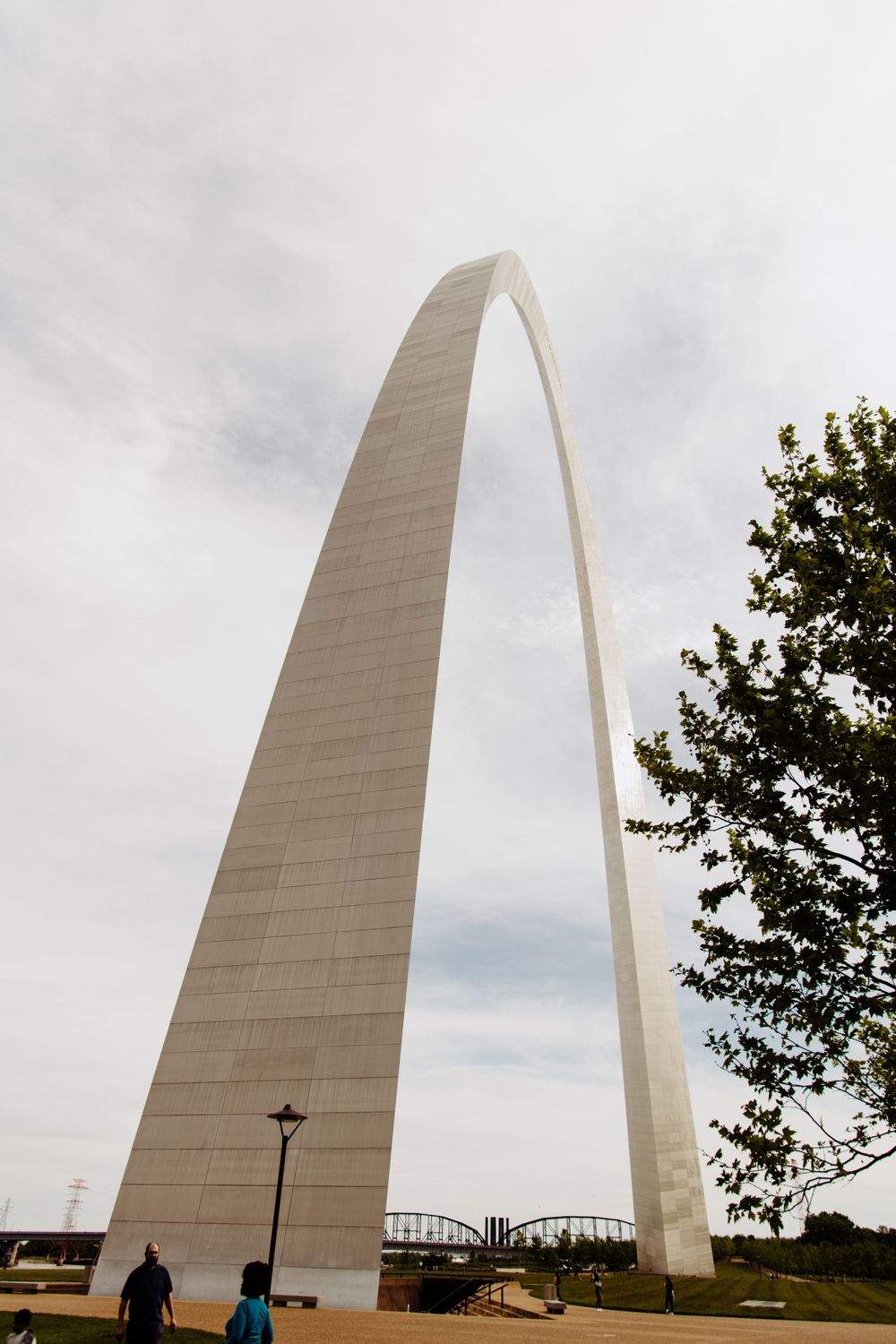 Gateway Arch in St. Louis photographed from multiple angles against cloudy sky.