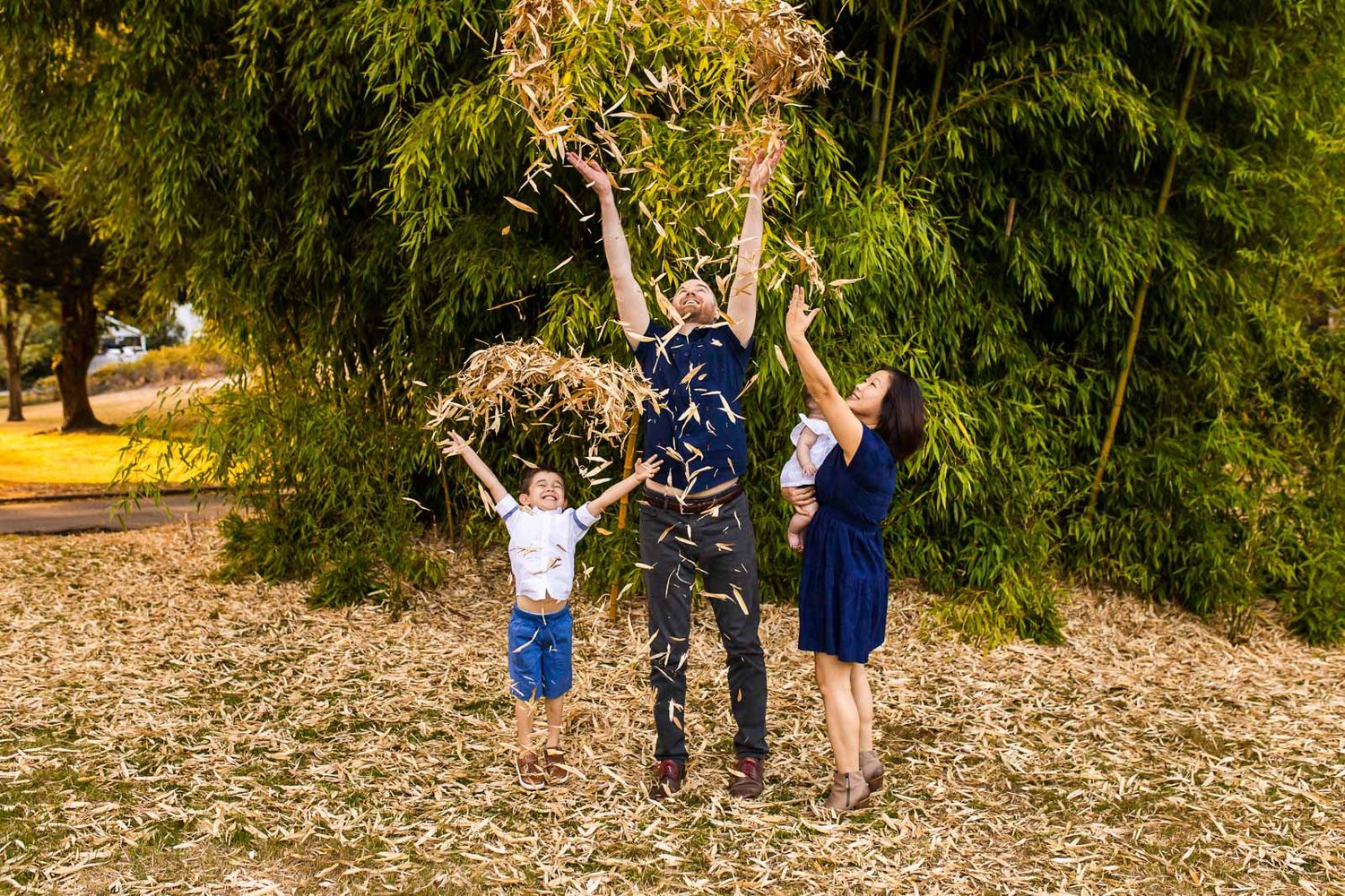 Family throwing bamboo leaves at McAuliffe Park