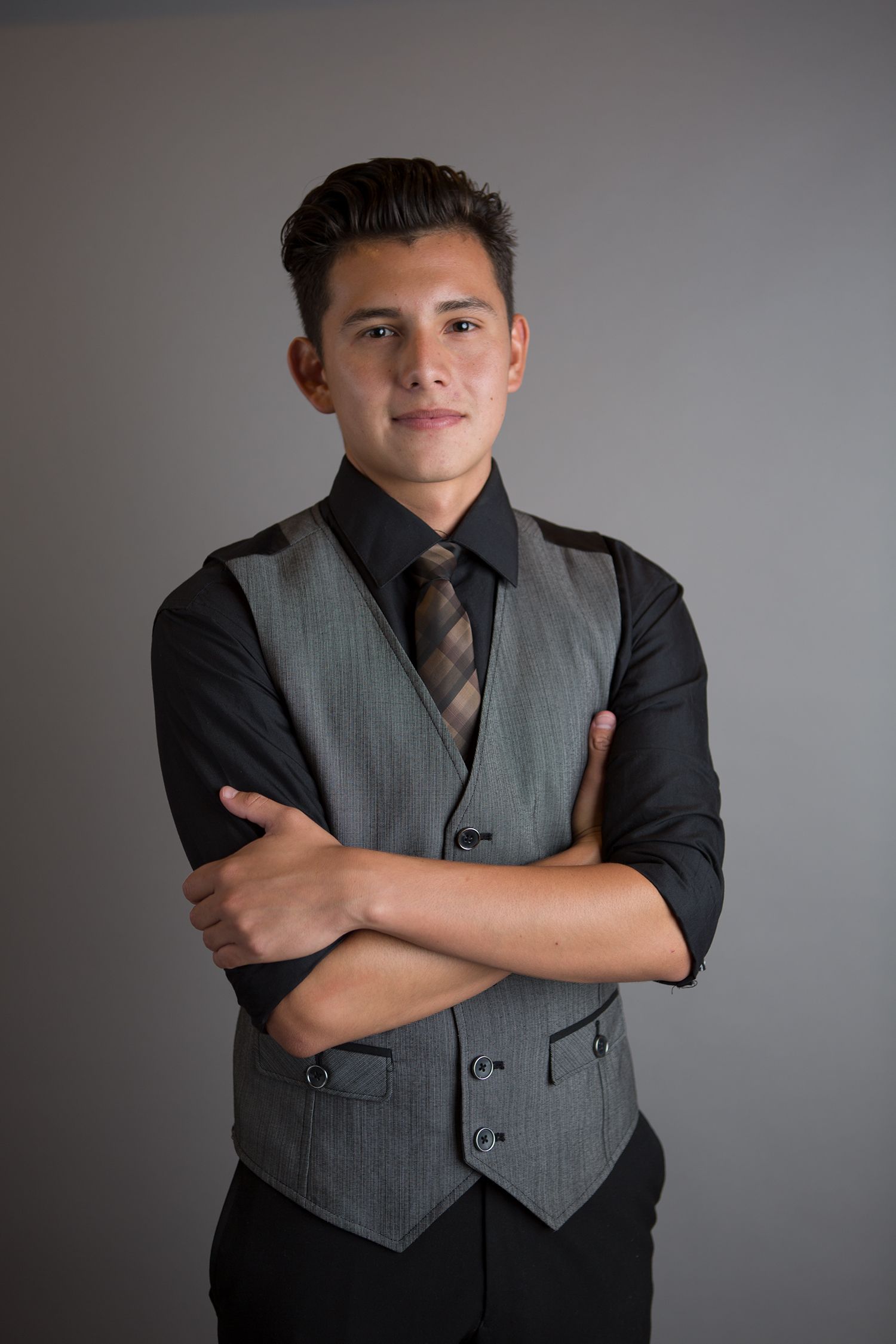 Person wearing formal vest and black shirt in professional studio portrait.