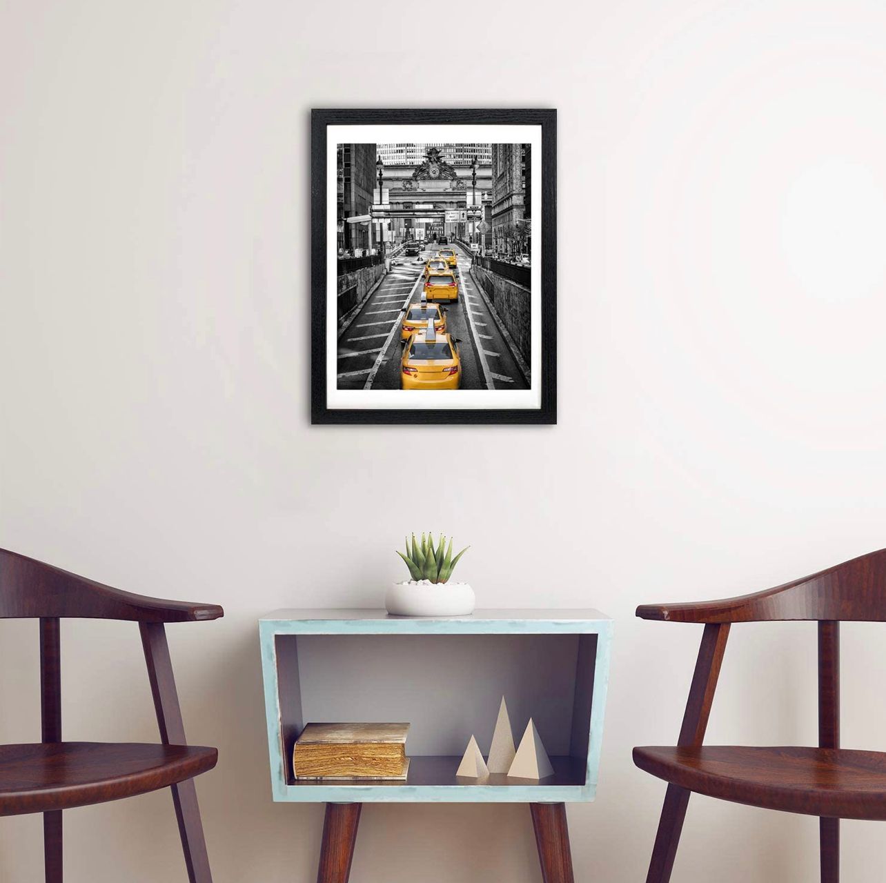 Black and white NYC street photo with yellow taxis, framed art print hanging above mid-century modern console table.