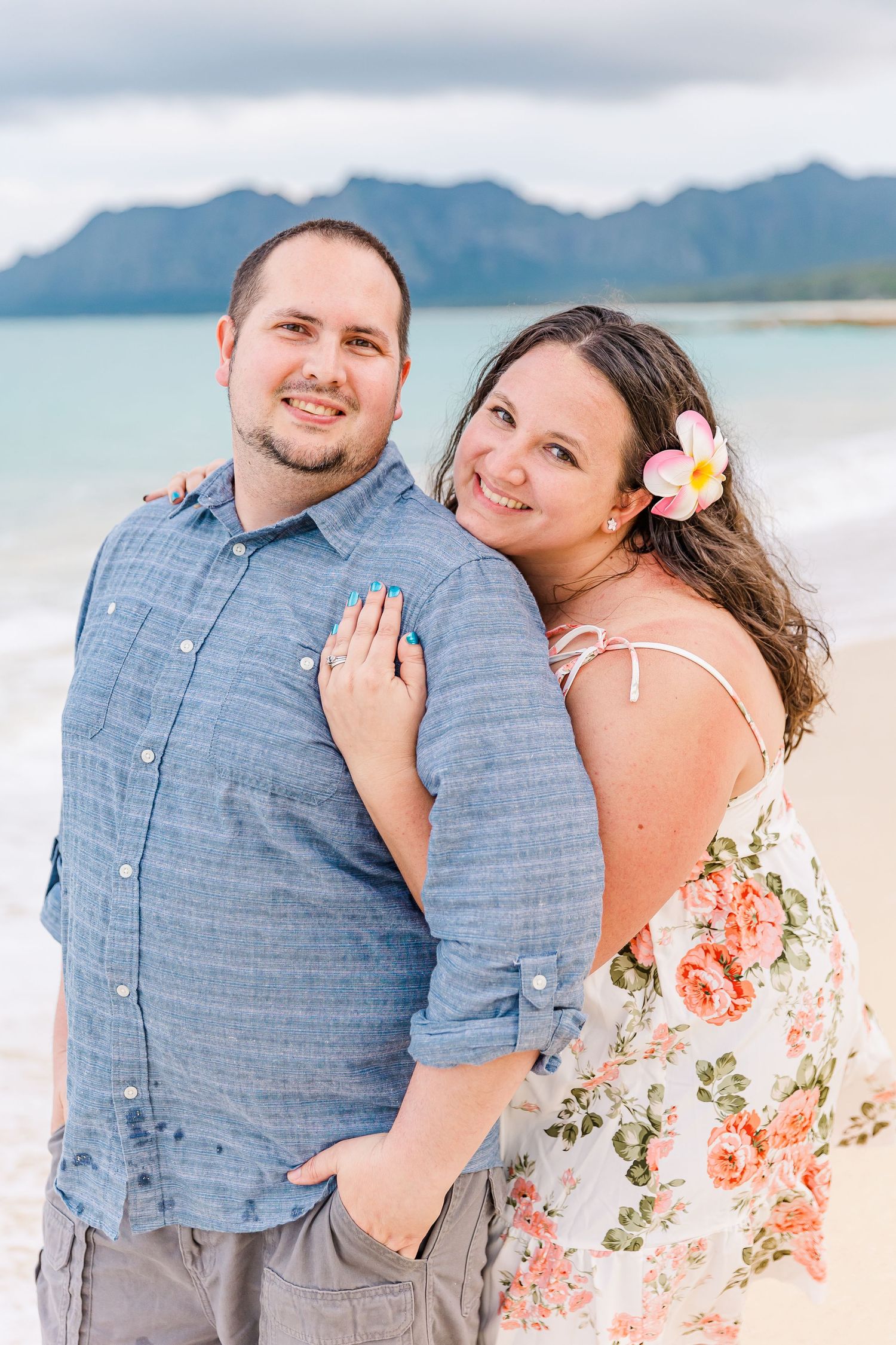 A romantic beach portrait with mountains and ocean in the background.