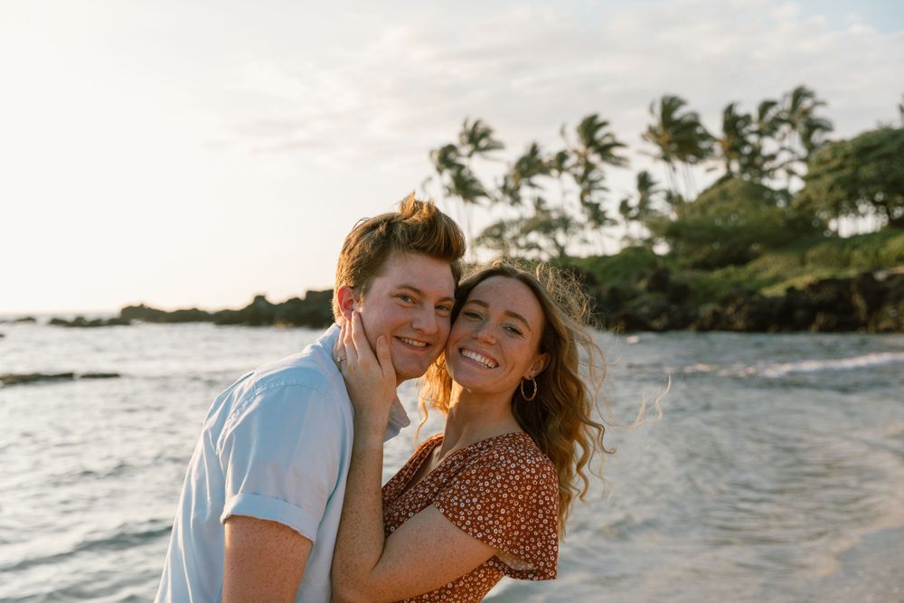 Romantic sunset portrait of couple laughing together on a Hawaiian beach.
