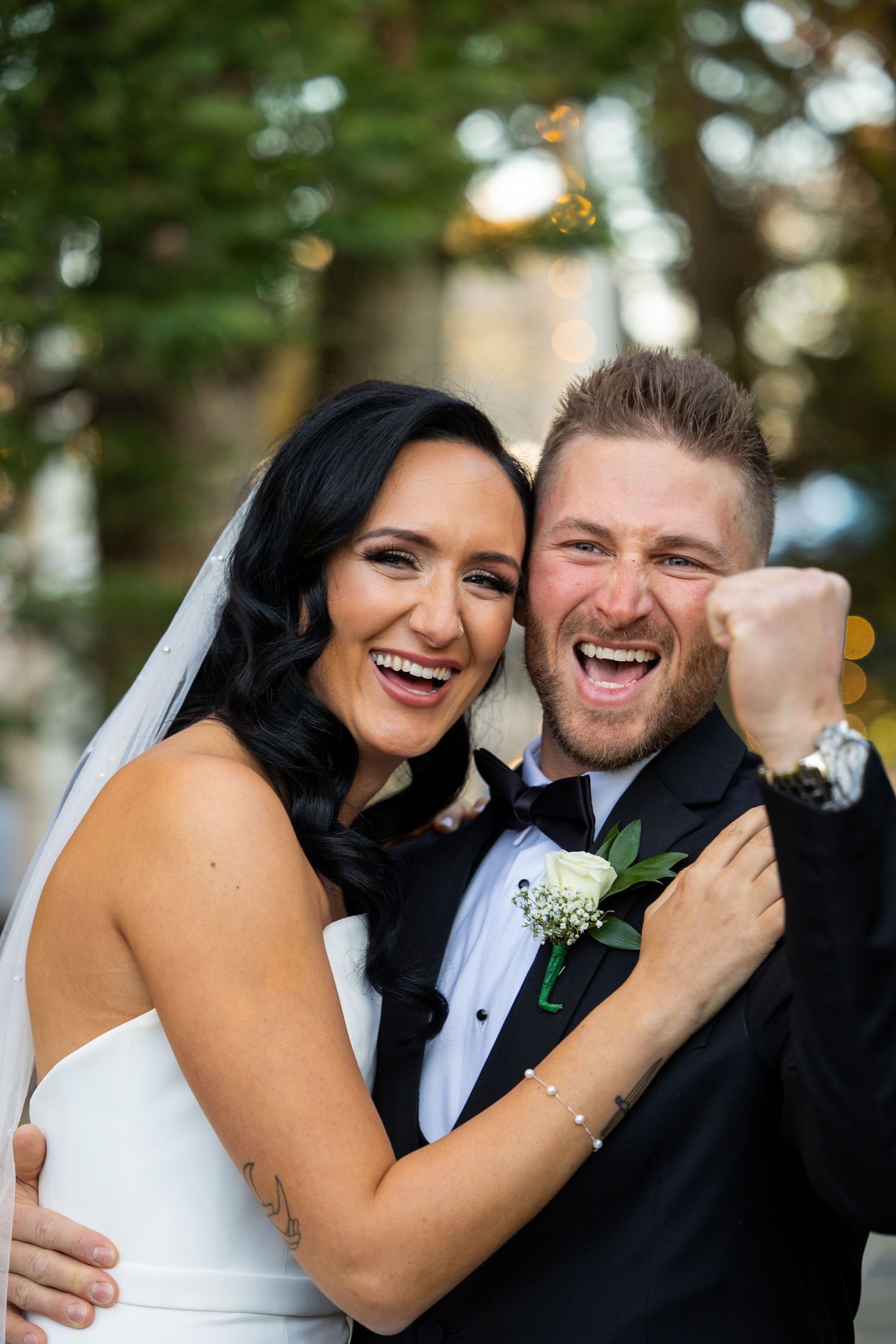 A candid moment of pure joy captured during a wedding celebration outdoors.