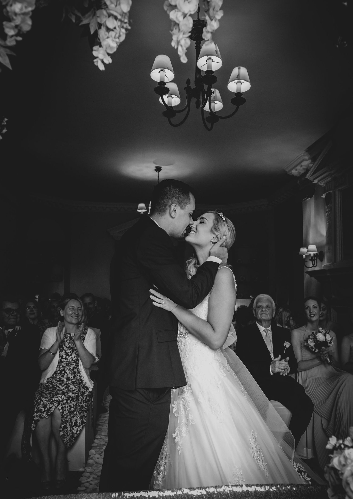 Black and white wedding reception dance floor scene with hanging lights and decorations.